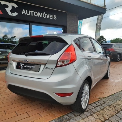 Carro Ford Fiesta prata estacionado fora da loja RC AUTOMÓVEIS
