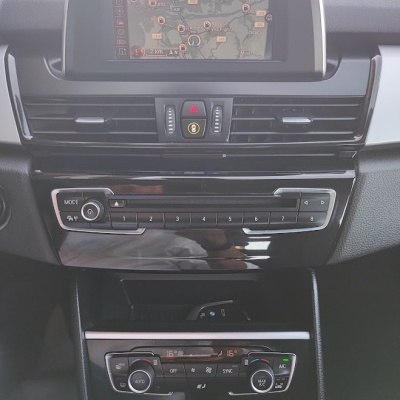 Painel de controlo interno de carro com sistema GPS, rádio e ar condicionado.