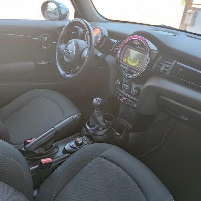 Interior de automóvel com volante, bancos e consola central em tons escuros