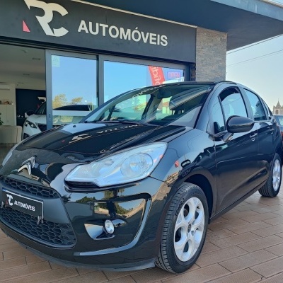 Carro Citroën preto em frente a loja RC AUTOMÓVEIS