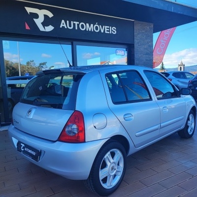 Carro Renault Clio prata numa loja de automóveis chamada RC AUTOMÓVEIS