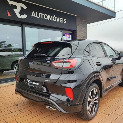 SUV preto Ford Puma estacionado em frente a loja RC AUTOMÓVEIS.