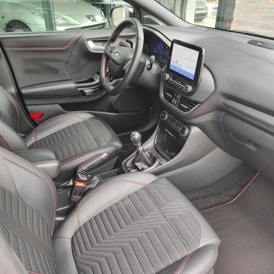 Interior de carro com bancos pretos e volante em couro