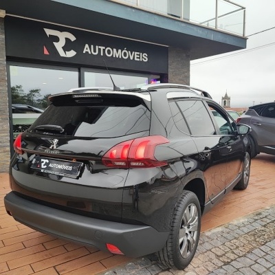 Automóvel Peugeot 2008 preto estacionado em frente à loja RC AUTOMÓVEIS