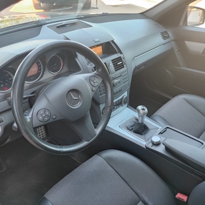 Interior de carro Mercedes-Benz com volante preto e assentos em tecido preto