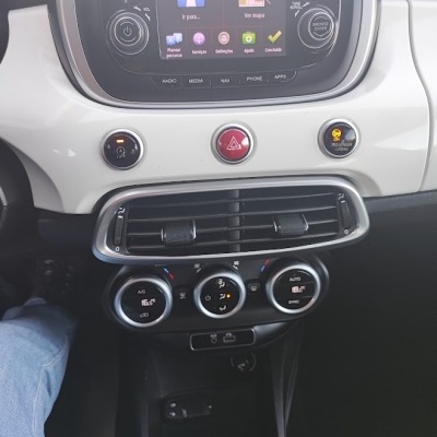 Painel central de carro com sistema de navegação TomTom, controles de ar condicionado e caixa de velocidades manual.