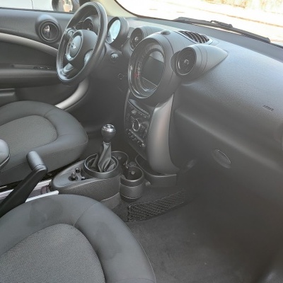 Interior de automóvel com volante, bancos cinzentos e painel com mostradores circulares e botões