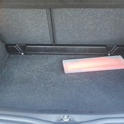 Mala de carro com carpete cinzenta, luz interior acesa, lanterna de emergência branca com luz vermelha