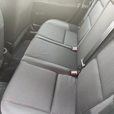 Banco traseiro de carro em tecido cinzento escuro com cintos de segurança