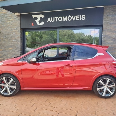 Carro citadino vermelho GTi estacionado em loja de automóveis