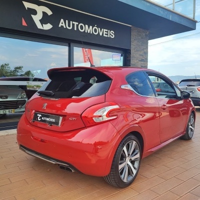 Peugeot GTi vermelho estacionado em frente à loja RC AUTOMÓVEIS