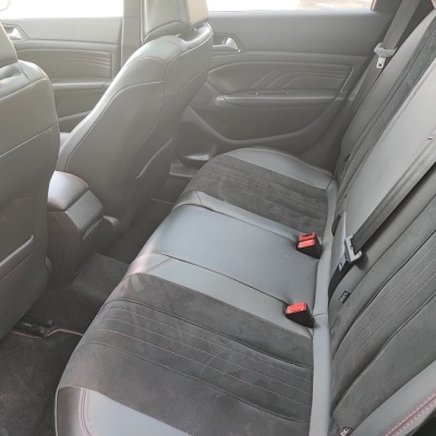 Interior traseiro de carro com bancos em pele e camurça cinza escuro com costuras vermelhas