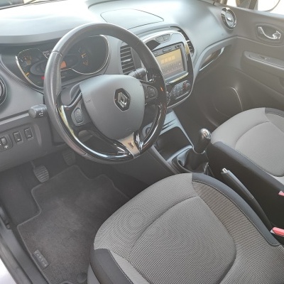 Interior de carro Renault com volante preto e bancos cinza