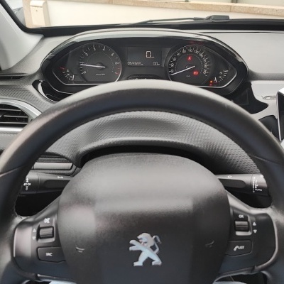 Volante Peugeot em pele preta com painel de instrumentos analógico e digital e interior de carro preto e cinzento