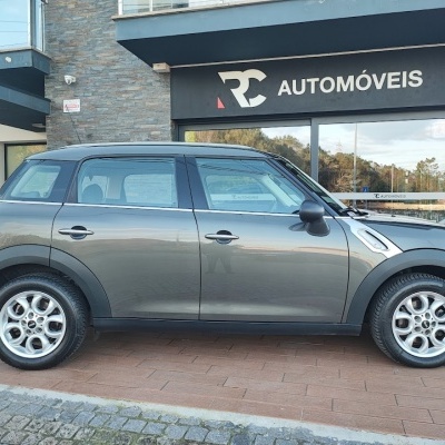 Carro cinzento metálico estacionado diante de loja RC Automóveis