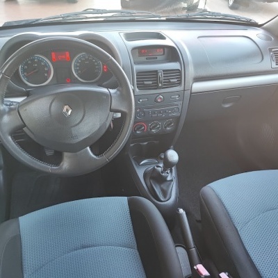 Interior de automóvel Renault com volante em couro preto e estofos azuis em tecido.