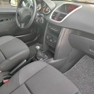 Interior de carro Peugeot com bancos cinza e painel preto