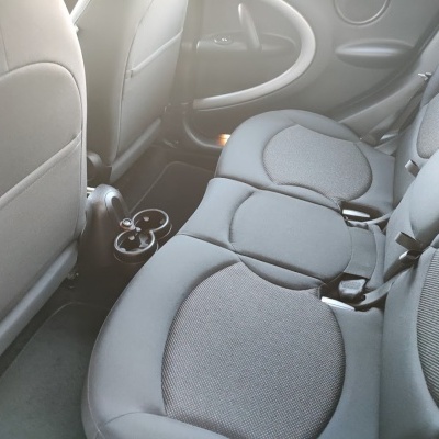 Interior de carro com bancos traseiros cinzentos em tecido.