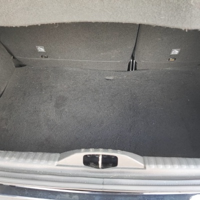 Bagageira de carro forrada a carpete preta com ícones ISOFIX e borda metálica