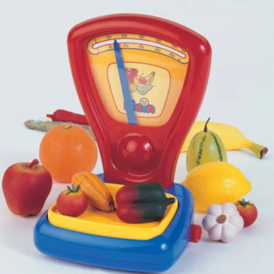 Balança de brinquedo em plástico colorida com frutas e legumes de brinquedo ao redor