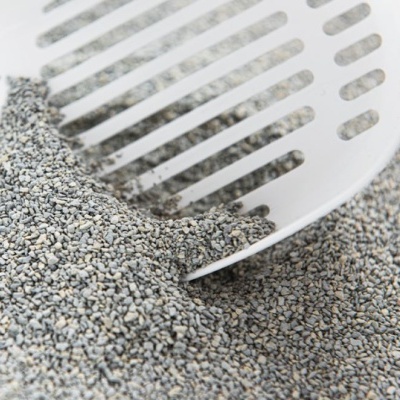 Pá branca de plástico numa areia cinzenta com pequenas partículas