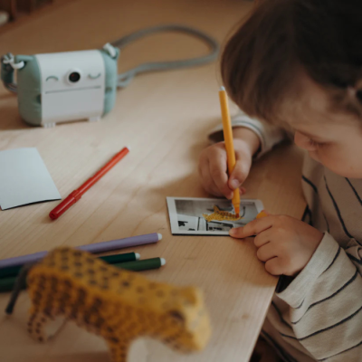 Câmara instantânea retro verde e branca com criança a colorir fotografia instantânea