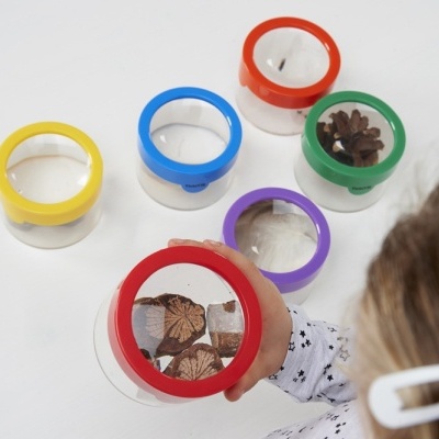 Conjunto de lupas coloridas com objetos naturais em mesa branca