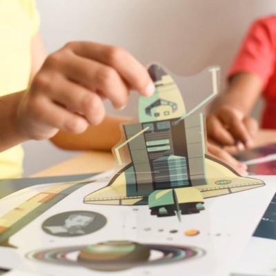 Foguetão espacial em folha transparente sobre folha com planetas e gráficos coloridos