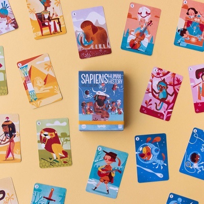 Cartas de jogo ilustradas e caixa azul do jogo Sapiens Human History