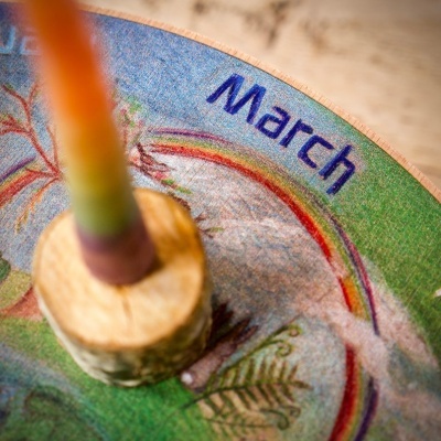 Calendário redondo de madeira decorativo com mês March e castiçal no centro
