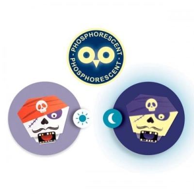 Dois adesivos redondos de caveiras de pirata fosforescentes, um de dia e outro à noite.