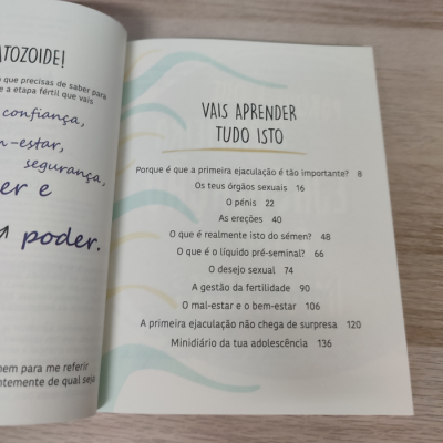 Livro aberto com sumário em português sobre educação sexual sobre uma mesa de madeira clara.