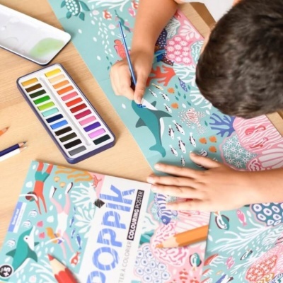 Criança a pintar poster marinho com lápis de cor e aguarelas