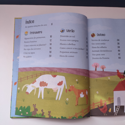 Livro infantil aberto mostrando índice com ilustrações de vacas e paisagem campestre colorida