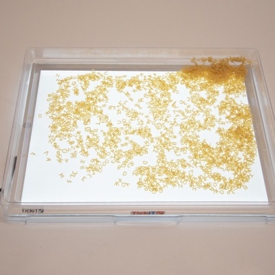 Caixa transparente com tampa, base espelhada e grânulos amarelos