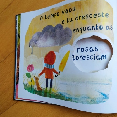 Ilustração colorida de livro infantil com texto e recorte em página aberta