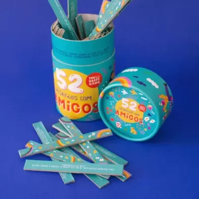 Embalagem do jogo 52 Desafios com Amigos e tiras de papel em fundo azul