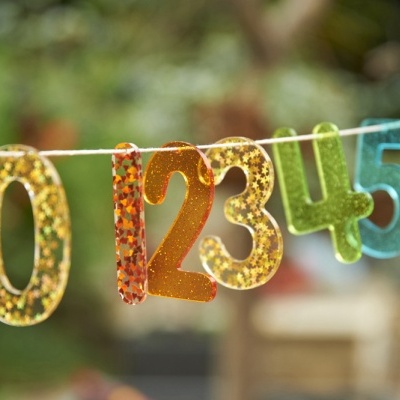 Números decorativos coloridos pendurados num cordão ao ar livre