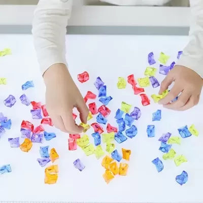 Mãos de criança a brincar com blocos de construção coloridos