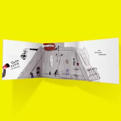 Livro infantil aberto com ilustrações de gato e casa e texto em português