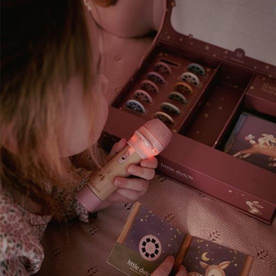 Criança com microfone de madeira e caixa decorativa com cartões infantis