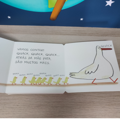 Página de livro infantil com ilustrações de pata e patinhos com texto em português