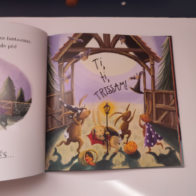 Ilustração de coelhos vestidos de feiticeiro num livro infantil aberto com texto Ti, ti, TRISSAM!