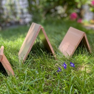 Três peças de madeira em forma de 'A' sobre relva verde