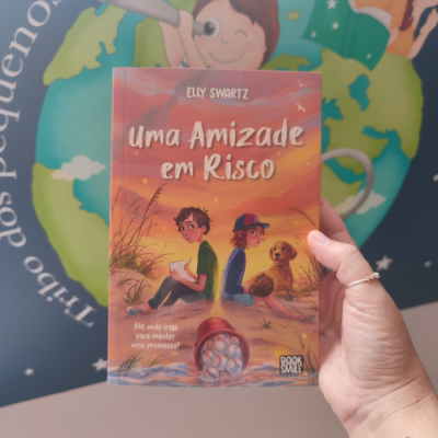 Capa de livro infantil 'uma Amizade em Risco' com crianças e cachorro na praia