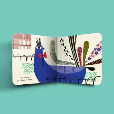 Livro infantil aberto mostrando pavão azul colorido com gravata vermelha e coroa preta