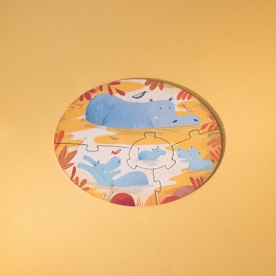 Puzzle circular com hipopótamos azuis em fundo amarelo com folhas.