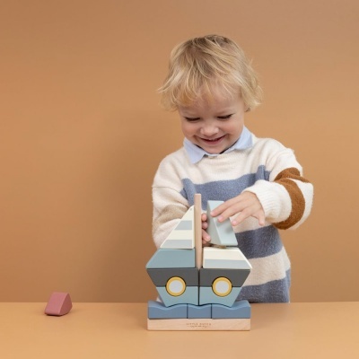 Criança loira a brincar com brinquedo de blocos de madeira coloridos