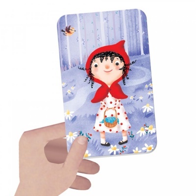 Cartão ilustrado com menina de casaco branco de bolinhas vermelhas e capuz vermelho numa floresta