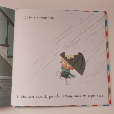 Ilustração de criança com guarda-chuva e texto em português num livro infantil aberto.